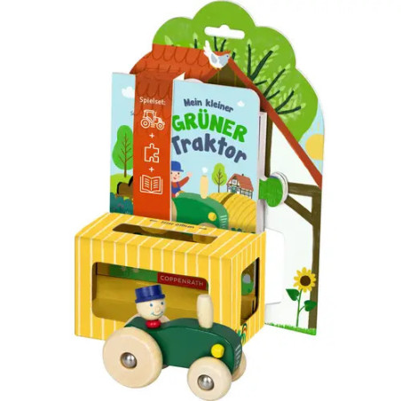 Grüner Holztraktor mit kleinem Fahrer, im Hintergrund eine bunt illustrierte Verpackung.