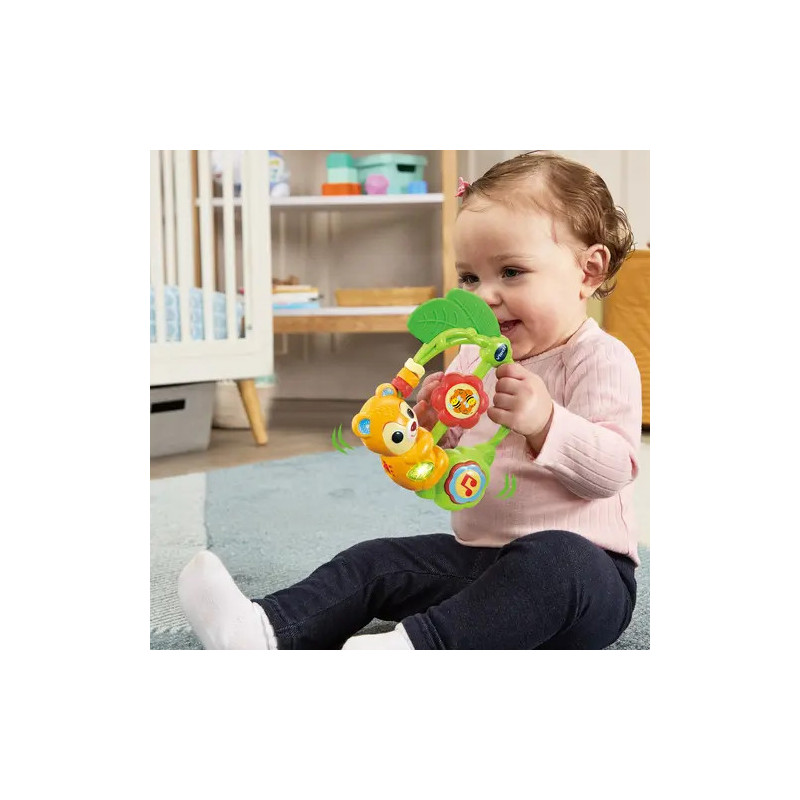 Ein lächelndes Baby spielt auf einem blauen Teppich im Kinderzimmer mit buntem Spielzeug.