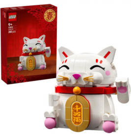 LEGO-Set einer weißen Glückskatze mit pinken Details, Goldmünze und rotem Halsband, Verpackung im Hintergrund.