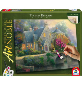 Eine Hand malt Blumen auf ein Thomas-Kinkade-Häuschen auf einem Premium-Malkasten von Schmidt.