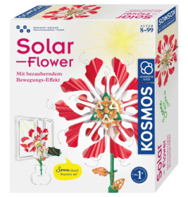 Box eines Kosmos Solar-Flower Sets mit einer rot-rosa mechanischen Blume im Sonnenlicht.