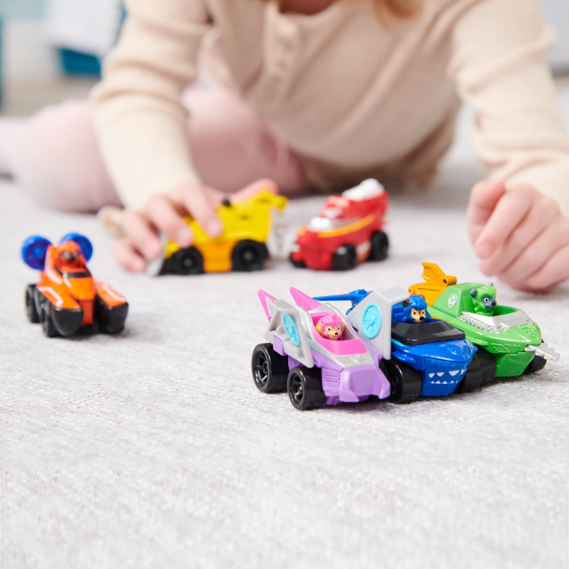 Kind spielt auf Teppich mit bunten Spielzeugautos, die Tiermotive zeigen.