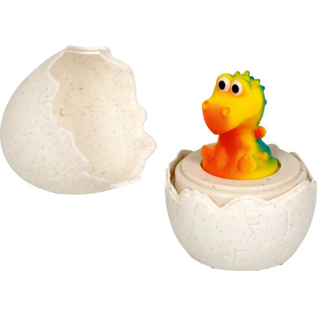 Bunter Spielzeug-Dinosaurier schlüpft aus einem aufgebrochenen weißen Ei, neben ihm liegt ein Teil der Eierschale.