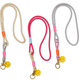 Drei bunte Seil-Lanyards mit Metallclips und gelben Kugelanhängern liegen nebeneinander auf weißem Hintergrund.