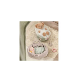 Zwei kleine Plüschtiere liegen in Betten mit Decken auf beige gemustertem Untergrund neben einem Häkeldeckchen.