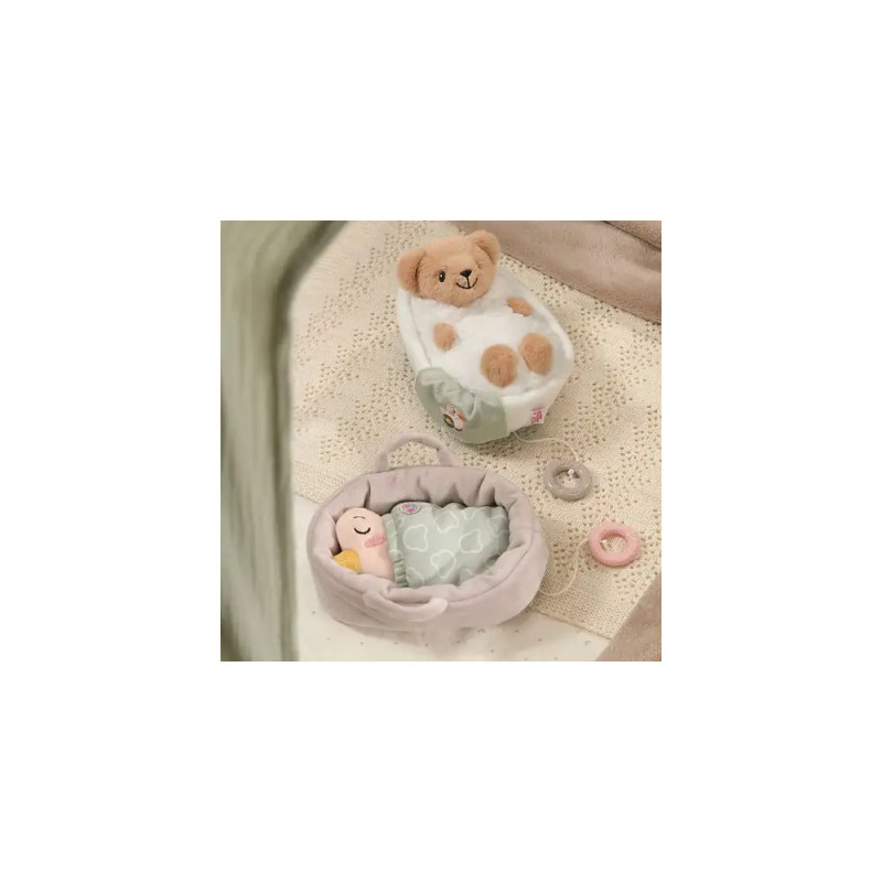 Zwei kleine Plüschtiere liegen in Betten mit Decken auf beige gemustertem Untergrund neben einem Häkeldeckchen.