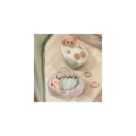 Zwei kleine Plüschtiere liegen in Betten mit Decken auf beige gemustertem Untergrund neben einem Häkeldeckchen.