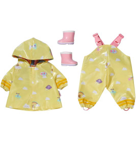 Gelbes Puppen-Regenmantelset mit Kapuze, Latzhose und rosa Stiefeln, verziert mit Wolken und Regenbögen.