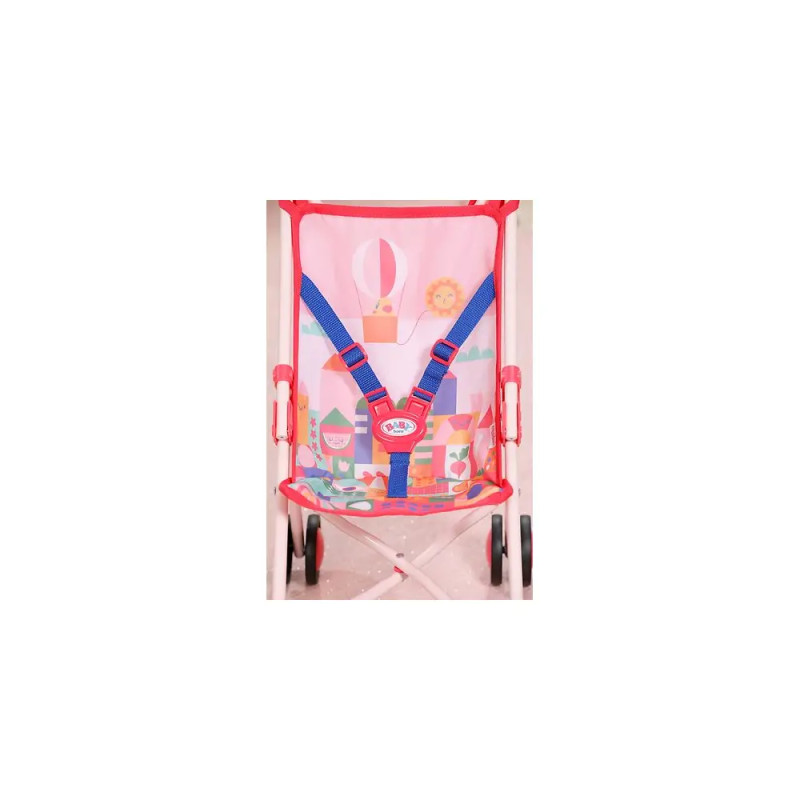 Nahaufnahme eines rosa Puppenwagensitzes mit bunten Mustern und blauen Sicherheitsgurten.