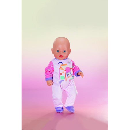 Eine Babypuppe in buntem Schlafanzug steht vor einem Hintergrund mit rosa und grünem Farbverlauf.