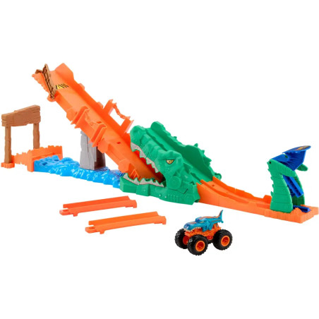 Orange Spielzeug-Rennbahn mit grünem Krokodil-Hindernis und blau-orangefarbenem Monstertruck neben der Bahn.