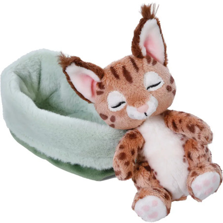Ein Plüschluchs mit geschlossenen Augen sitzt neben einem weichen, hellgrünen Haustierbett.