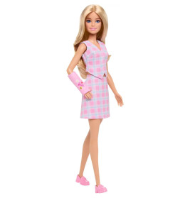 Barbie-Puppe im rosa Kleid, pinken Schuhen und mit einem rosa Gips am Arm, verziert mit Herzen und Smileys.