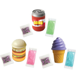 Spielzeug-Dose, Burger und Eis mit bunten Tütchen und lila Süßigkeiten drumherum arrangiert.