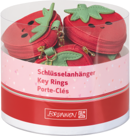 Runder Behälter mit roten Erdbeer-Schlüsselanhängern mit Gesicht, beschriftet auf Deutsch, Englisch und Französisch.