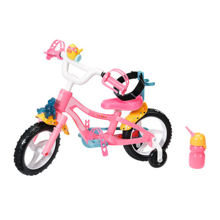Pink-weißes Kinderfahrrad mit Stützrädern, Frontkorb, Helm und pinker Trinkflasche daneben.