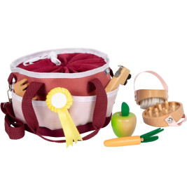Spielset zur Pferdepflege: Bürsten, gelbes Band, Holzapfel, Karotte und Tasche in Maroon-Weiß.