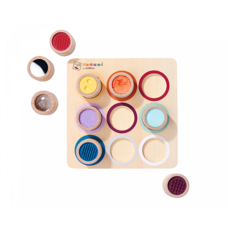 Montessori-Sinnesbrett mit neun strukturierten Holz-Zylindern und passenden farbigen Ringen auf quadratischer Basis.