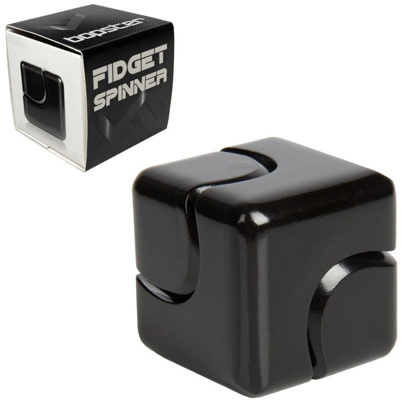Ein schwarzer Fidget Cube liegt neben einer Box mit der Aufschrift "Fidget Spinner" in weißen Buchstaben.