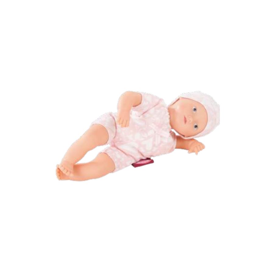 Eine Babypuppe im rosa Outfit und mit weißer Mütze liegt seitlich auf weißem Hintergrund.