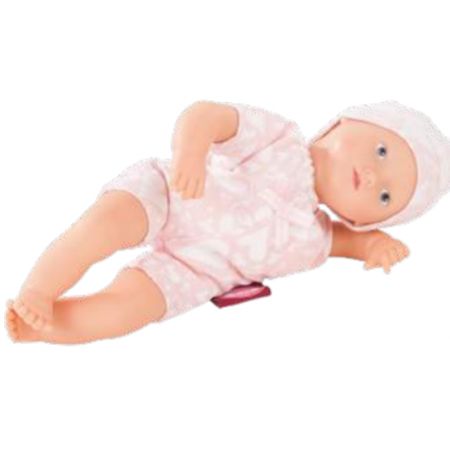 Eine Babypuppe im rosa Outfit und mit weißer Mütze liegt seitlich auf weißem Hintergrund.