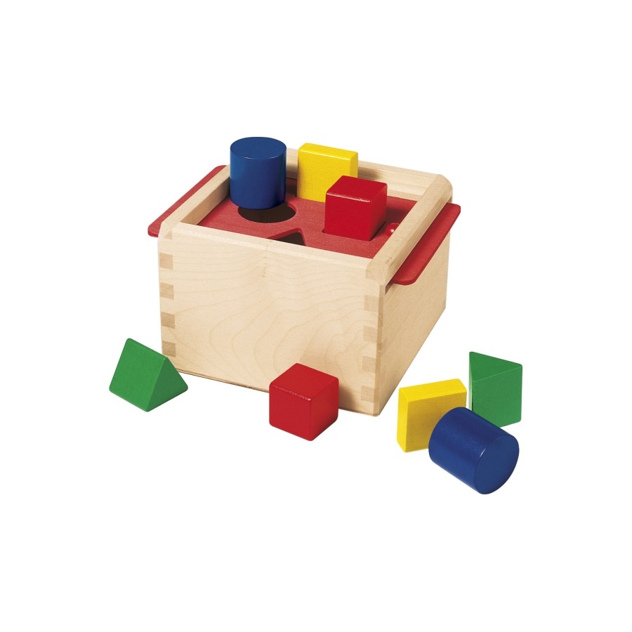 Holz-Formensortierbox mit bunten Klötzen wie Würfeln, Zylindern und Dreiecken liegt ringsum.