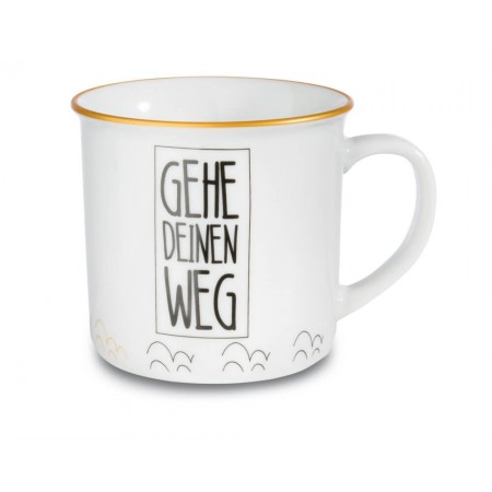 Weiße Tasse mit Goldrand, schwarzem Gehe deinen Weg-Schriftzug und kleinen Zierlinien am unteren Rand.