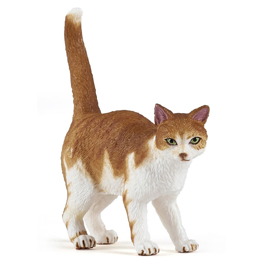 Eine braun-weiße Katzenfigur steht mit erhobenem Schwanz und blickt nach vorn.