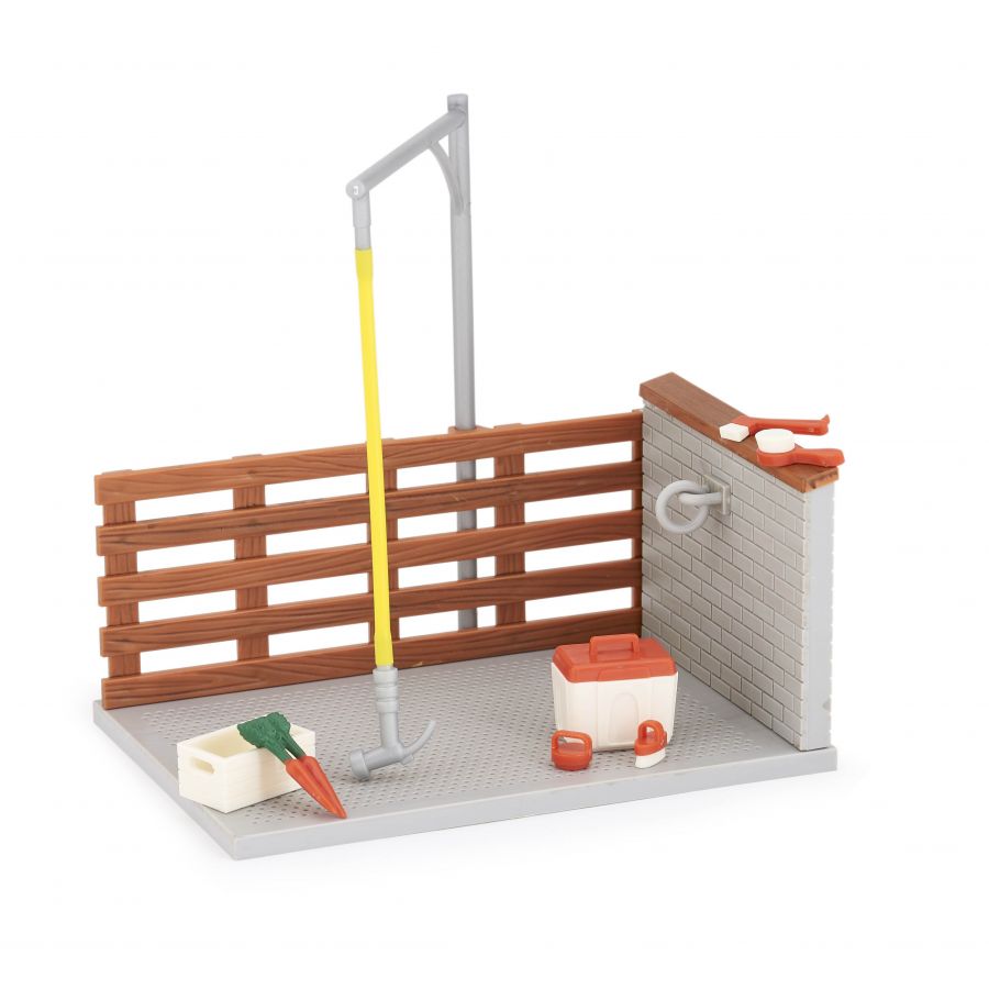 Spielzeug-Pferdestall mit Waschplatz, Schlauch, Eimer, Bürste, Karotte und Stein auf umzäuntem Sockel. Spielzeug-Pferdestall mit Waschplatz, Schlauch, Eimer, Bürste, Karotte und Stein auf umzäuntem Sockel.