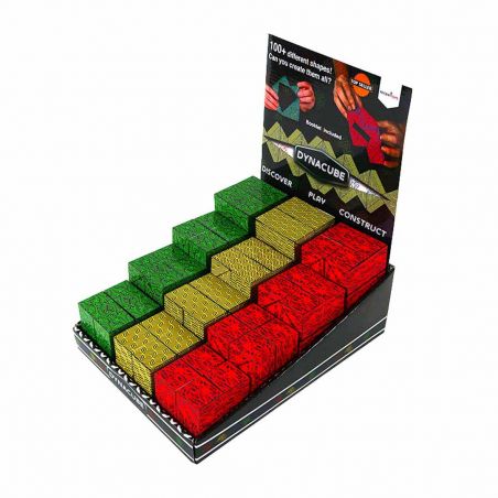 Display-Box mit Dynacube-Puzzles: grüne, gelbe und rote Würfel mit Mustern sind in Reihen angeordnet.