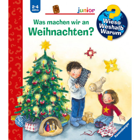 Zwei Kinder öffnen Weihnachtsgeschenke neben einem geschmückten Baum mit Kugeln und Kerzen.