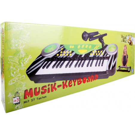 Verpackung eines Kinder-Keyboards mit 37 Tasten, Mikrofon und buntem Design vor grünem Hintergrund.