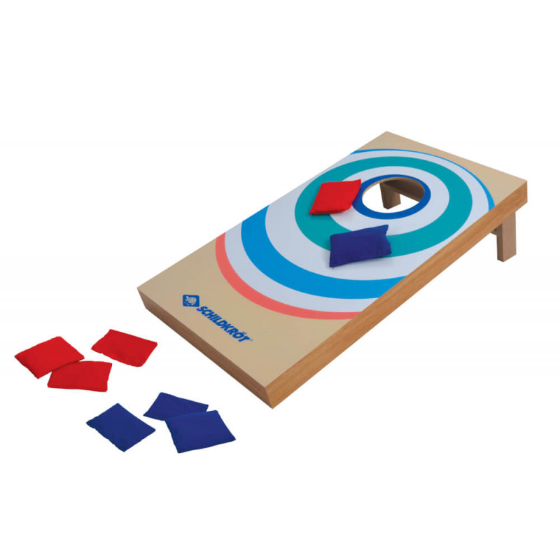 Ein Cornhole-Brett mit roten und blauen Säckchen, teils auf dem Brett, teils am Boden.