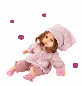 Eine Puppe mit braunen Haaren trägt rosa Kleidung und Mütze, sitzt mit rosa Spielzeug und rosa Punkten um sie herum.