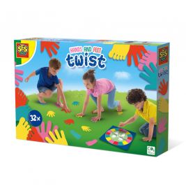 Drei Kinder spielen SES Hands and Feet Twist mit bunten Handabdrücken und Drehscheibe auf einer Wiese.