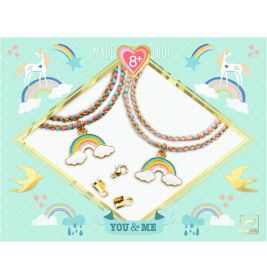 Zwei Halsketten mit Regenbogen-Wolken-Anhängern und pastellfarbenen Kordeln vor Einhorn- und Regenbogenmotiv.