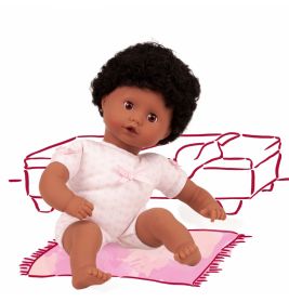 Eine Babypuppe im rosa Outfit sitzt auf einem Teppich vor einer schlichten Couchzeichnung im Hintergrund.