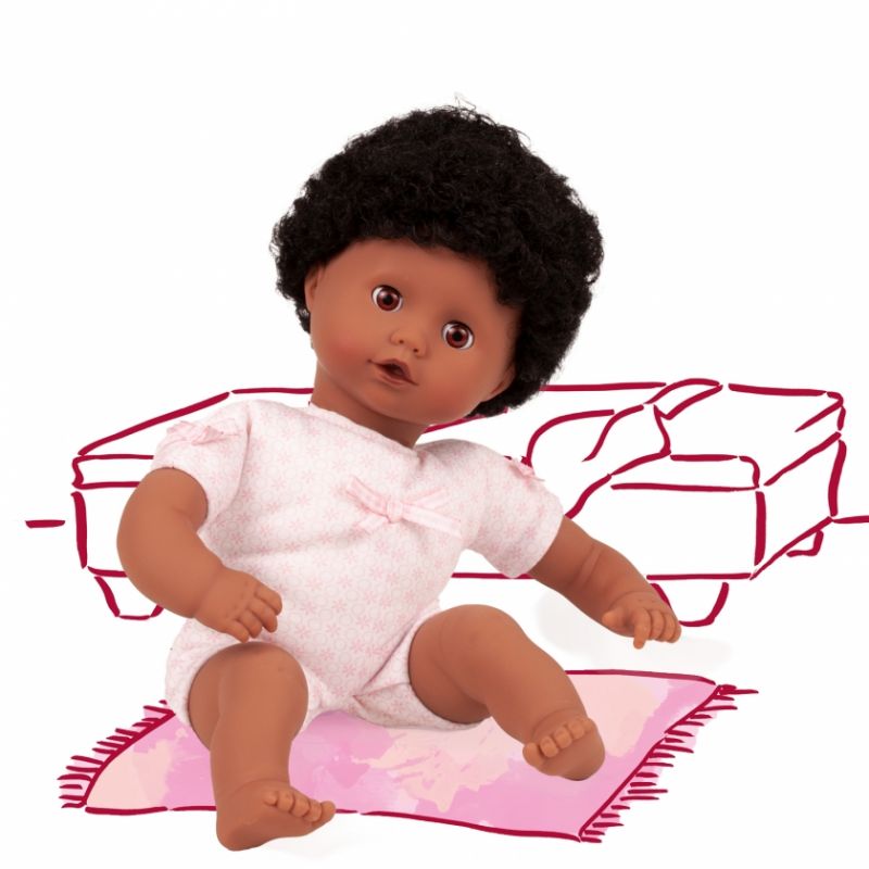 Eine Babypuppe im rosa Outfit sitzt auf einem Teppich vor einer schlichten Couchzeichnung im Hintergrund. Eine Babypuppe im rosa Outfit sitzt auf einem Teppich vor einer schlichten Couchzeichnung im Hintergrund.