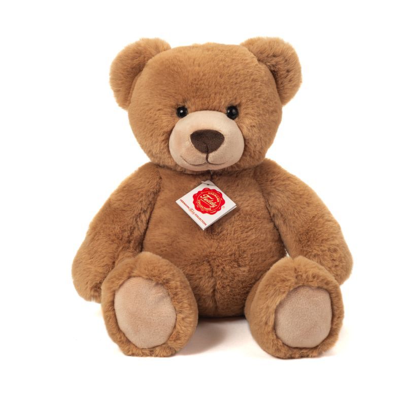 Brauner Plüsch-Teddybär mit rot-weißem Anhänger am Hals, sitzt aufrecht.