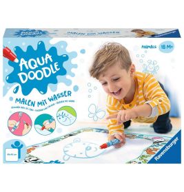 Ein Junge malt lächelnd mit einem Wasserstift auf einer Aqua Doodle Matte an einem Tisch.