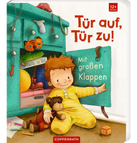 Ein lachendes Kind im gelben Pyjama sitzt am offenen Schrank, hält die Tür und hat Teddy sowie Spielzeug daneben.