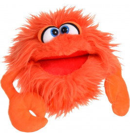 Ein rundes, orangefarbenes, zotteliges Puppentier mit großen Augen und klauenartigen Armen wirkt wie ein freundliches Monster.