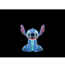 Ein blauer Cartoon-Alien mit großen Ohren und breitem Lächeln sitzt vor schwarzem Hintergrund.