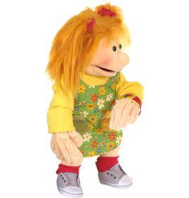 Eine Puppe mit orangefarbenen Haaren, gelbem Blumenkleid, roten Socken und grauen Sneakers sitzt seitlich.