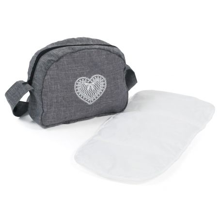 Graue Stofftasche mit Herzmotiv neben einer flach ausgebreiteten, weißen Wickelunterlage.