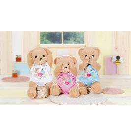 Drei Plüsch-Teddybären bedecken Augen, Ohren und Mund. Sie tragen bunte Kleidung und sitzen in einem Raum.