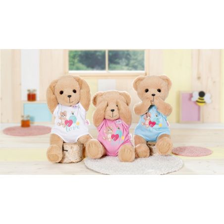 Drei Plüsch-Teddybären bedecken Augen, Ohren und Mund. Sie tragen bunte Kleidung und sitzen in einem Raum.