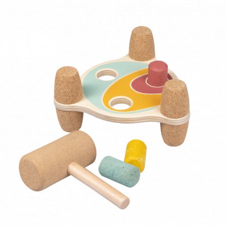 Holz-Klopfspielzeug mit bunten Stiften und Hammer auf kleinem Ständer mit drei Löchern.