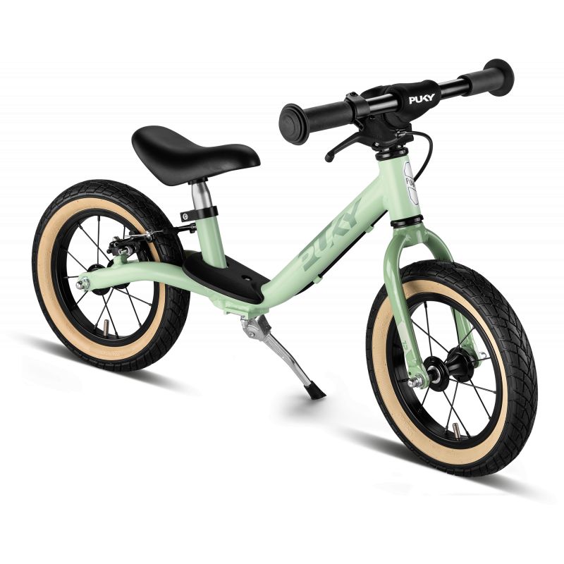 Hellgrünes Laufrad mit schwarzem Sitz, schwarzen Lenkern und cremefarbenen Reifen auf weißem Hintergrund.