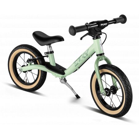 Hellgrünes Laufrad mit schwarzem Sitz, schwarzen Lenkern und cremefarbenen Reifen auf weißem Hintergrund.